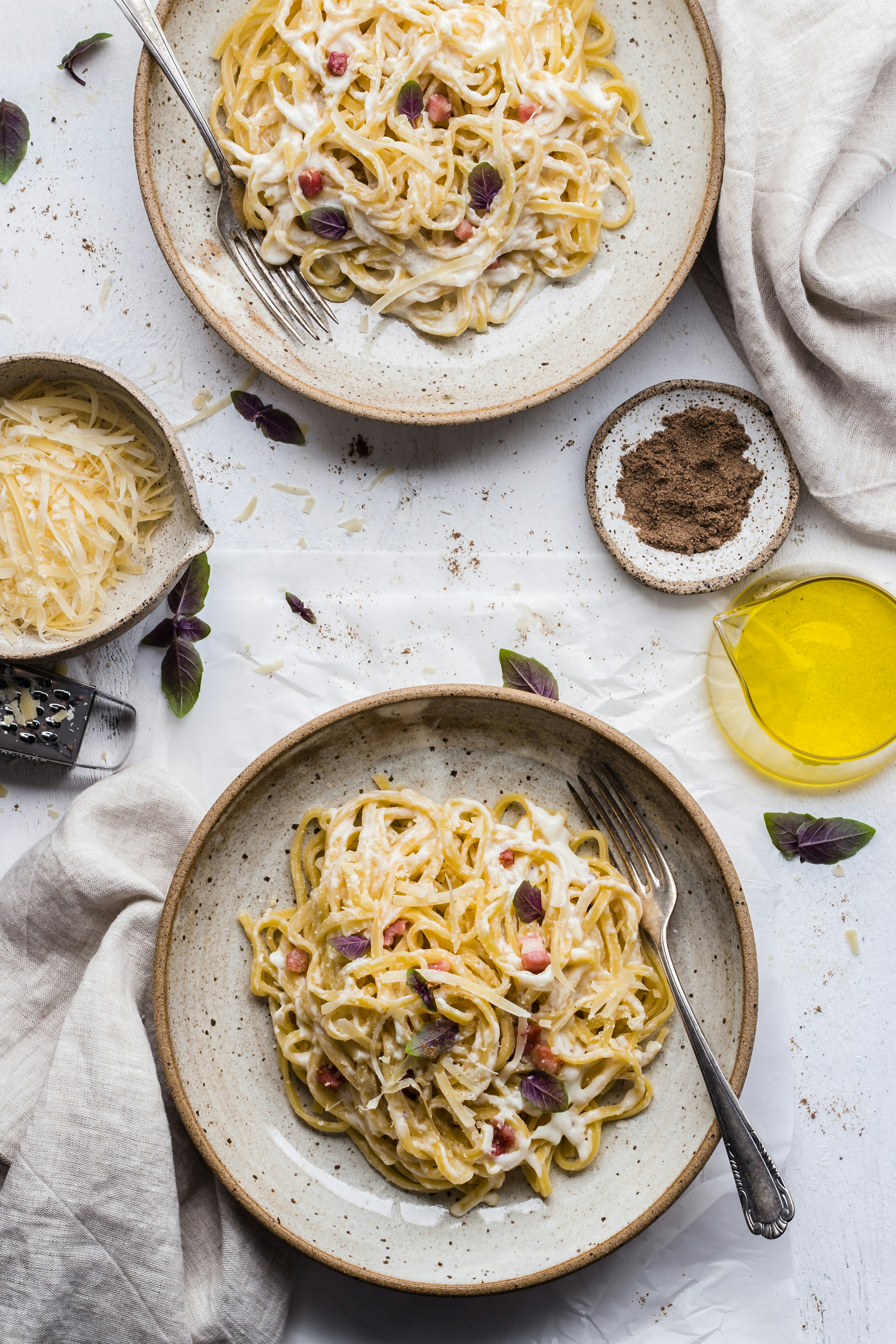 Cremige Pfeffer-Pasta mit Speck, Parmesan und Basilikum auf einem Teller